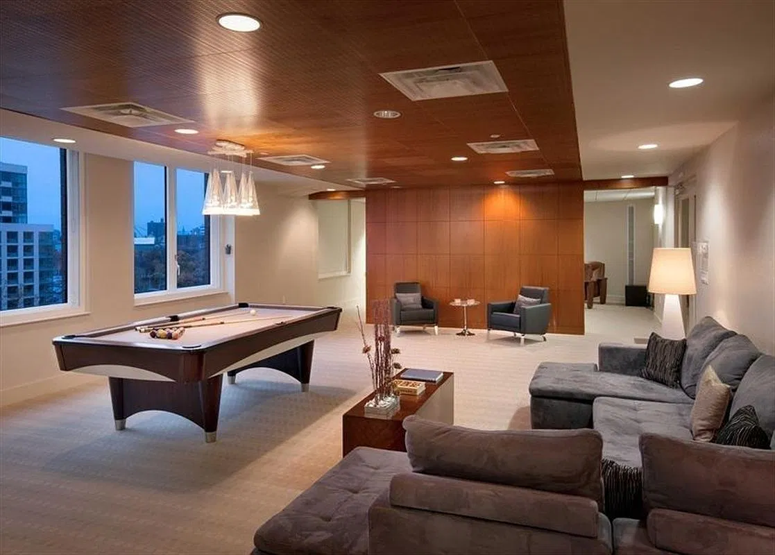 Thumbnail: Residents’ lounge with billiards table, gray sectional sofas and wood-paneled wall