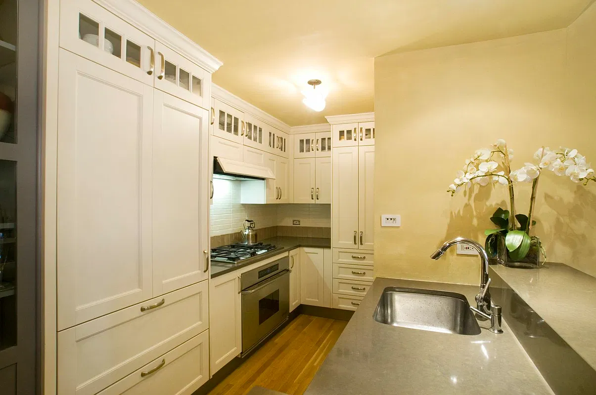 Thumbnail: Open kitchen with white custom cabinetry, gas cooktop, wall oven and quartz countertops