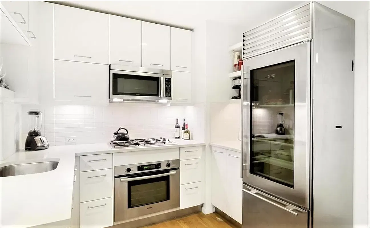 White kitchen with Bosch oven and microwave, gas cooktop and Sub-Zero glass-door refrigerator