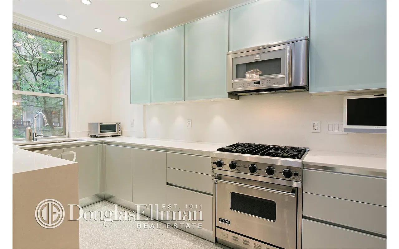 Thumbnail: Windowed kitchen with frosted-glass cabinets, Viking range and white stone countertops