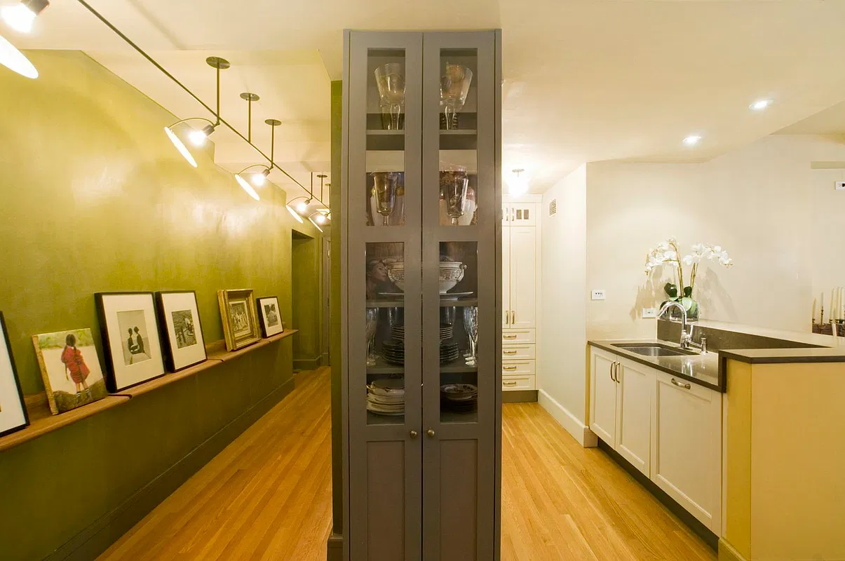 Thumbnail: Hallway gallery with picture ledge and glass-front cabinet opening to the kitchen