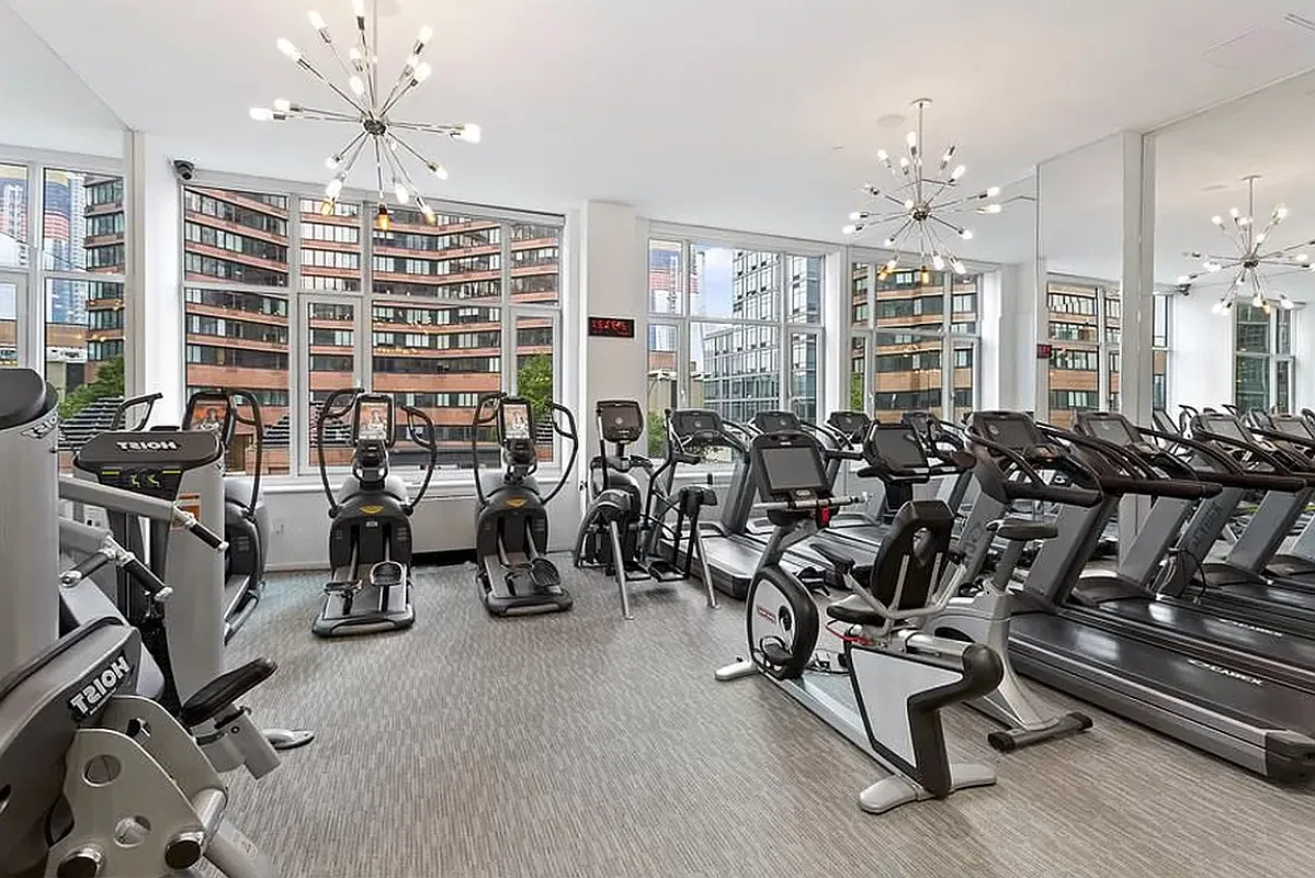Thumbnail: Building fitness center with treadmills, ellipticals and sputnik chandeliers