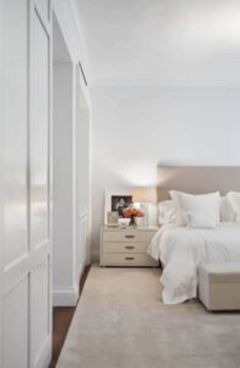 Thumbnail: Serene bedroom with paneled closets, upholstered headboard and white bedding