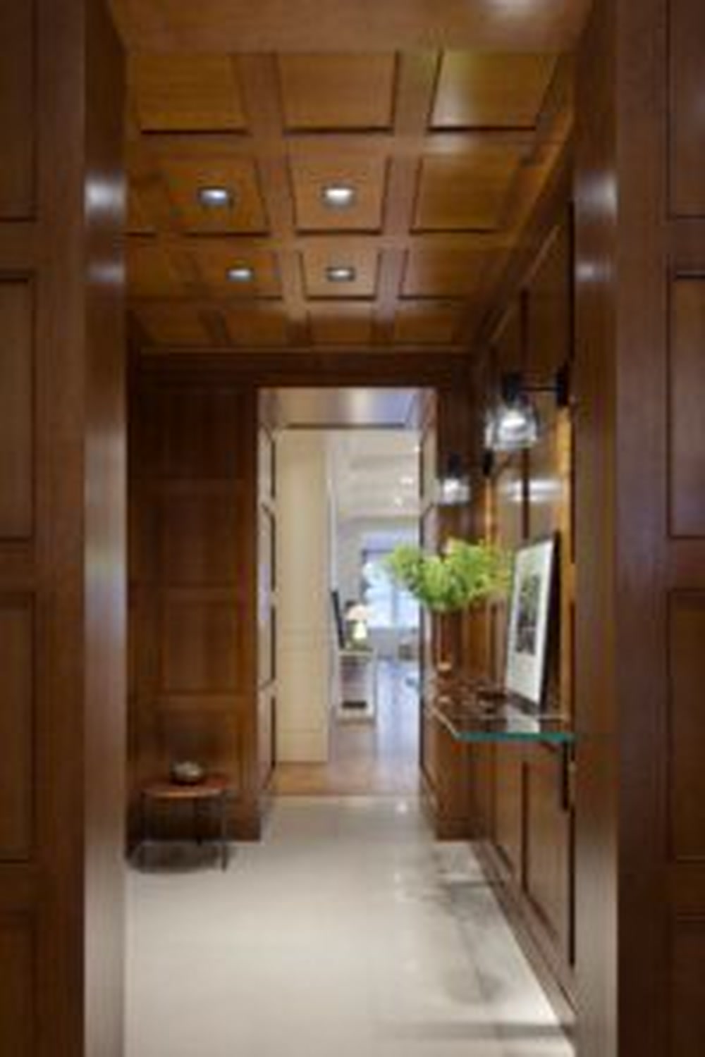 Thumbnail: Walnut-paneled private elevator vestibule with coffered ceiling and glass console