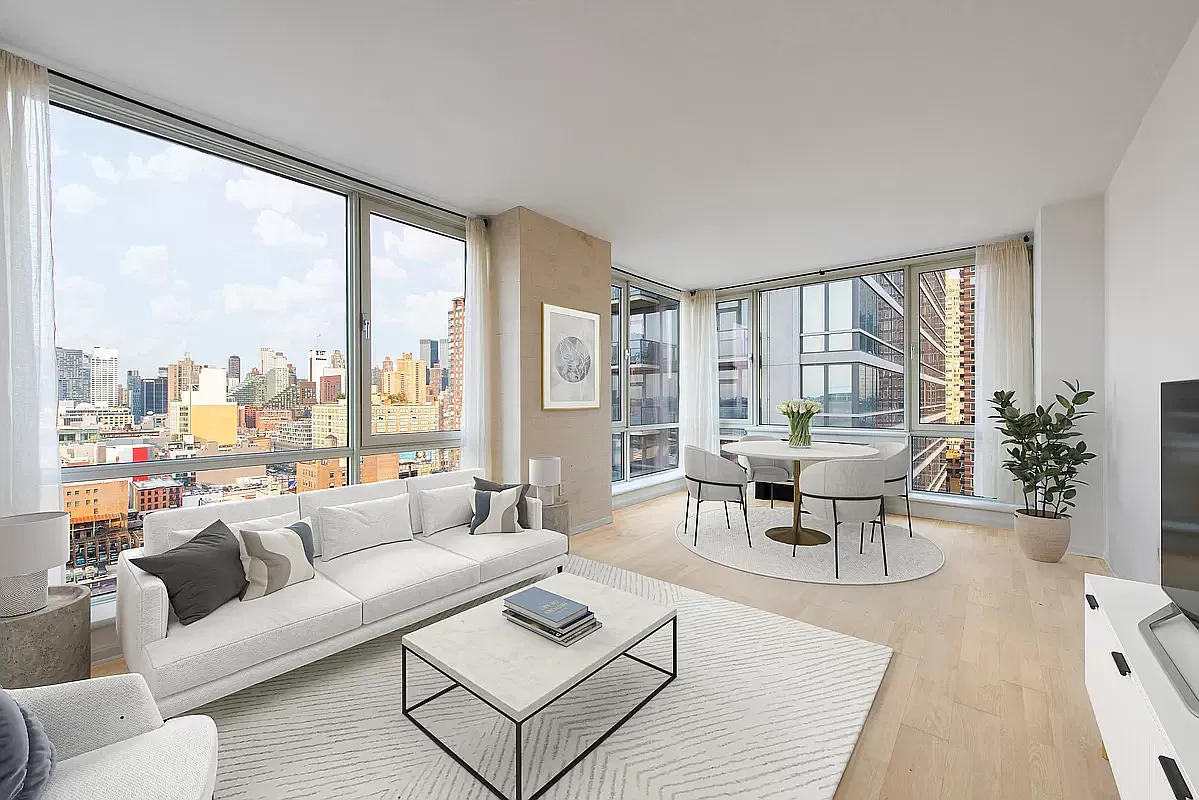 Bright corner living room with white sofa, marble coffee table and floor-to-ceiling windows overlooking Midtown