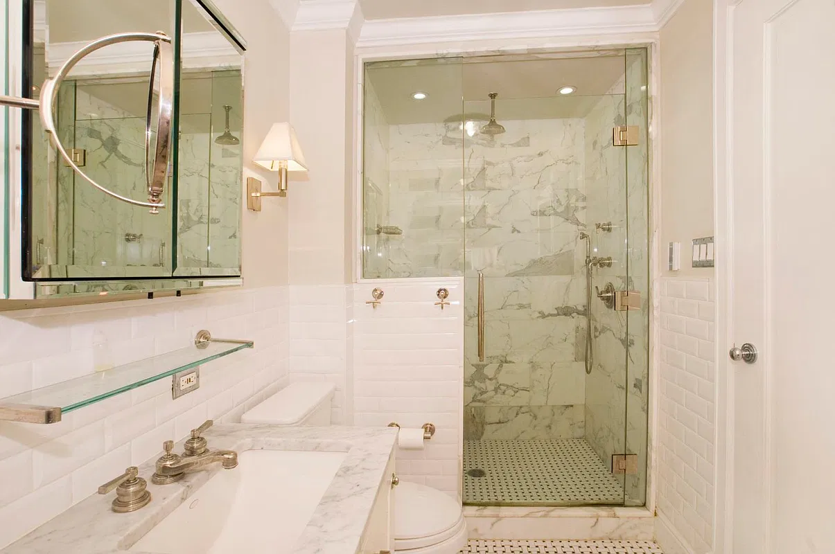 Thumbnail: Marble bathroom with glass-enclosed shower, subway tile and marble vanity