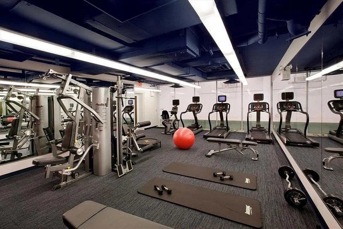 Thumbnail: Fitness center with treadmills, weight machines, mats and wall mirrors