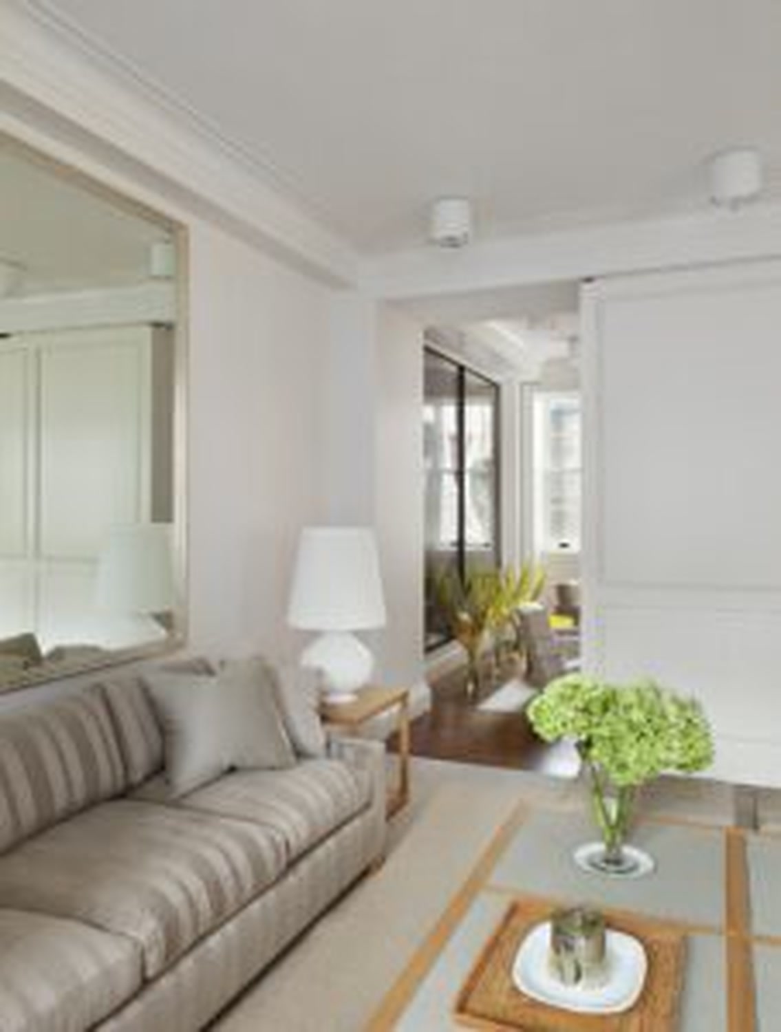 Thumbnail: Sitting area with striped sofa, wall mirror and view through to adjoining rooms
