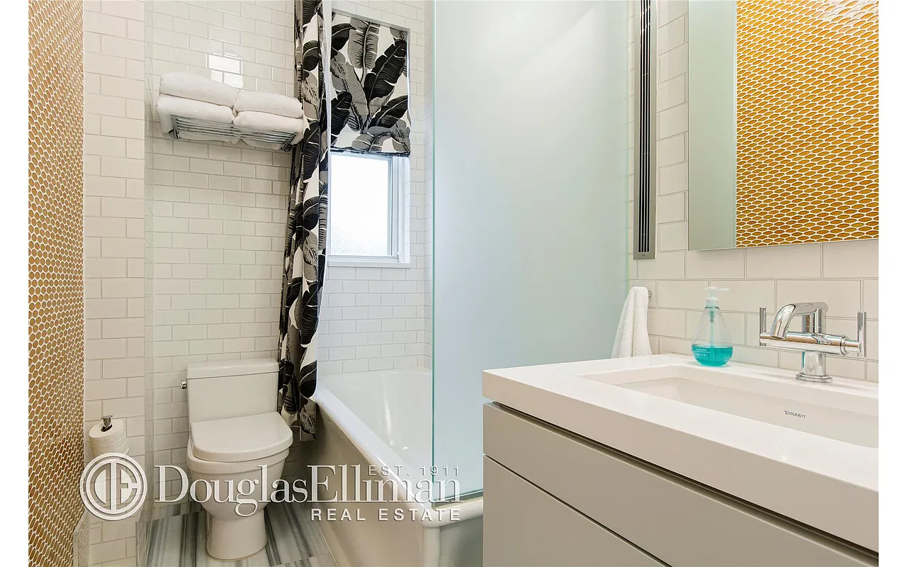 Thumbnail: Bathroom with subway tile, gold mosaic wall, tub with glass panel and floating vanity