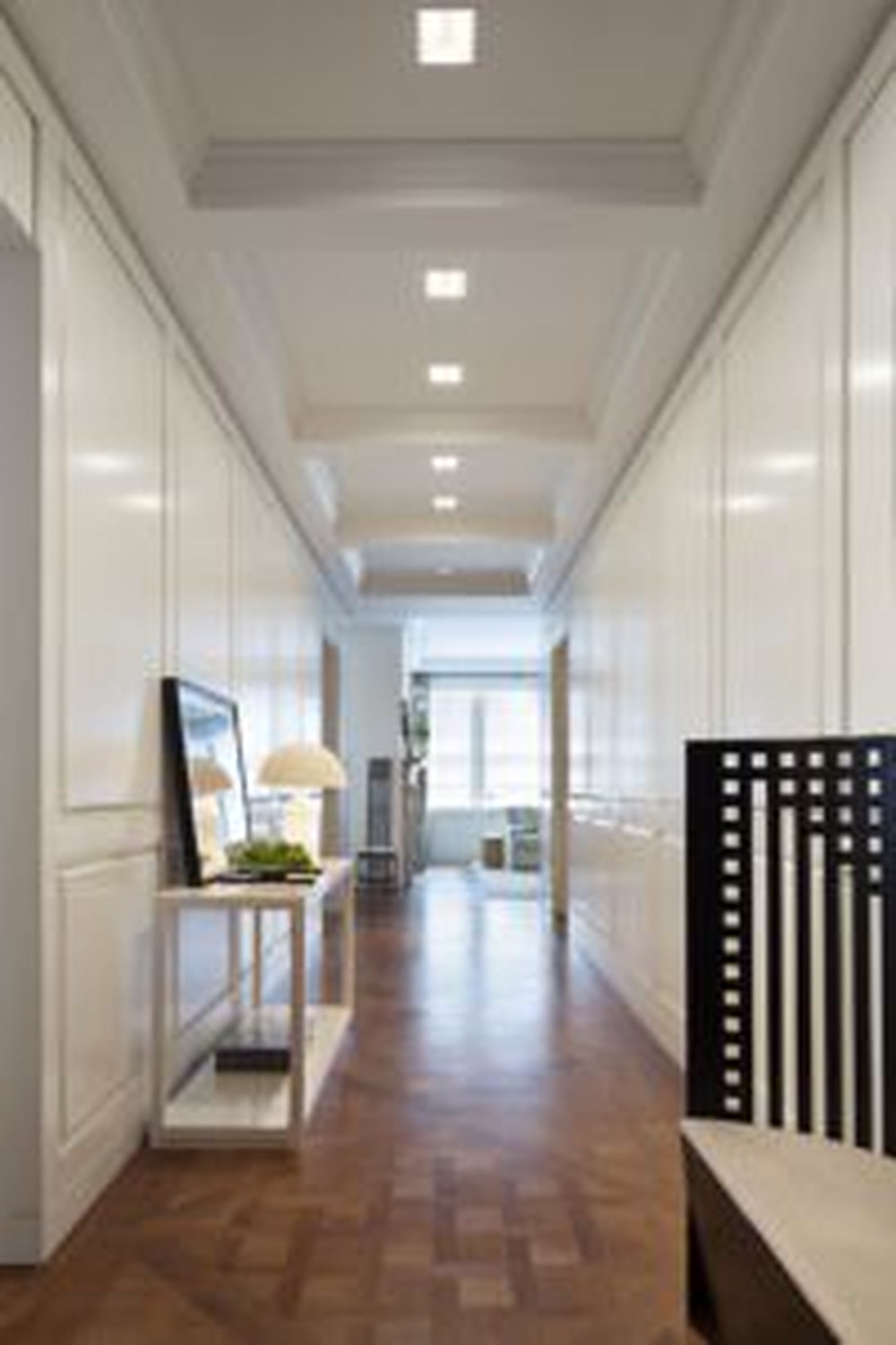 Thumbnail: Long paneled gallery with herringbone wood floors leading to bright corner rooms