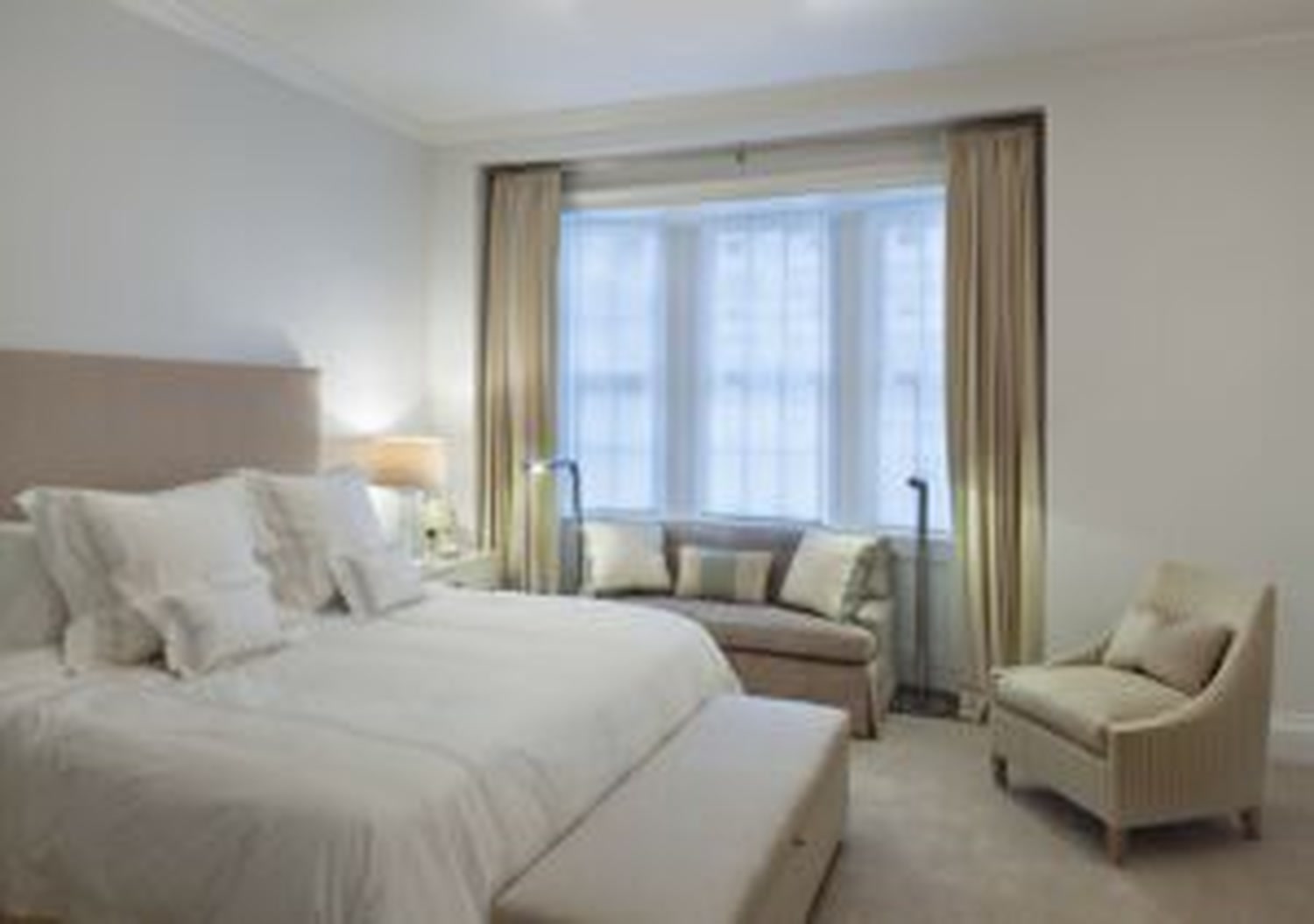Thumbnail: Bedroom with window seat in a curtained bay and upholstered armchair