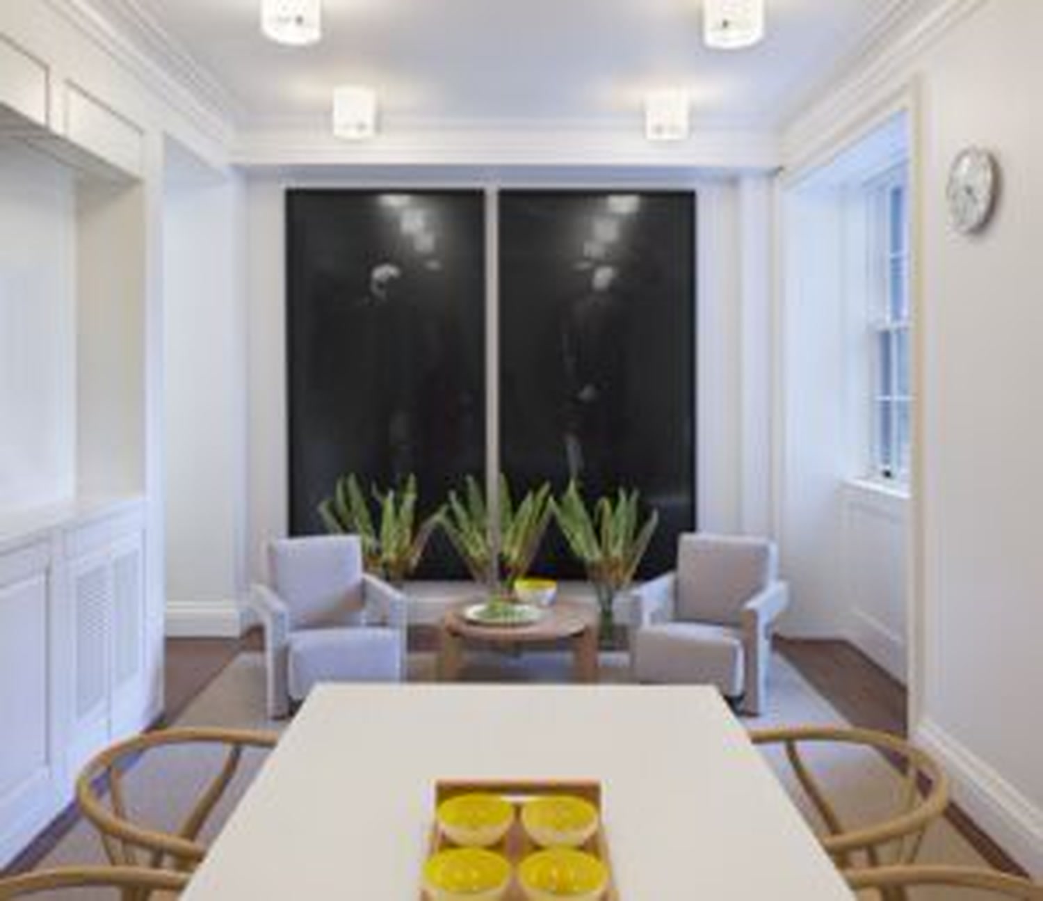 Thumbnail: Family room with large artwork, armchairs and dining table set for gathering