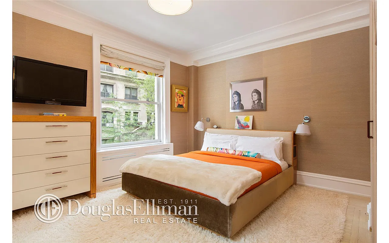 Thumbnail: Bedroom with grasscloth walls, upholstered bed and window overlooking tree-lined street