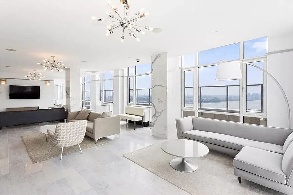 Thumbnail: Building lounge with gray sofas, marble columns and wide windows overlooking the river